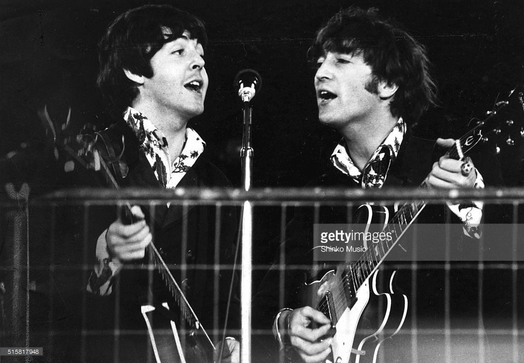 John Lennon and Paul McCartney of The Beatles share a microphone during the last concert on their final tour at Candlestick Park, San Francisco, California, August 29, 1966.