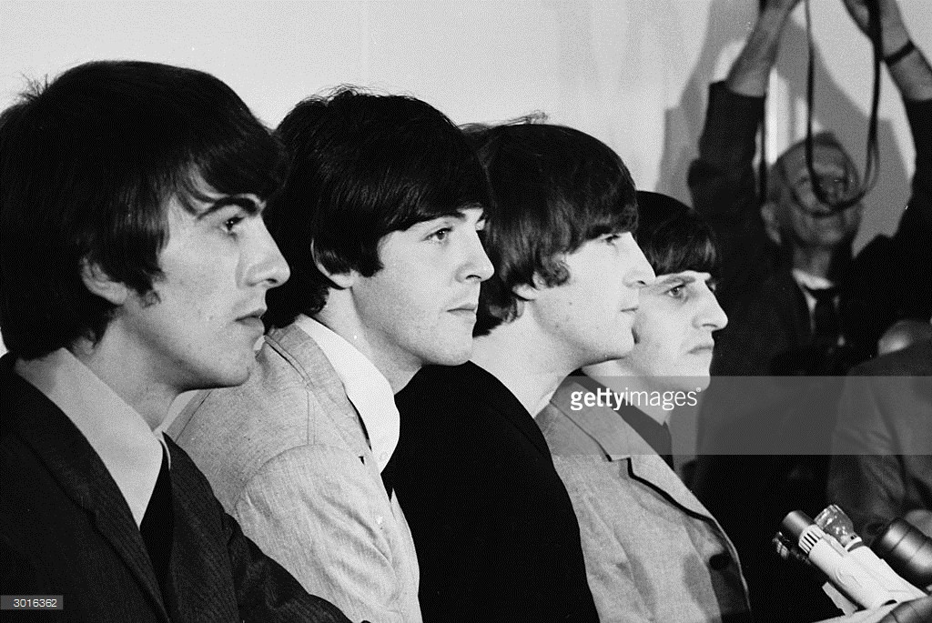 British pop group the Beatles, (L-R) George Harrison (1943 - 2001), Paul McCartney, John Lennon (1940 - 1980), and Ringo Starr listen to questions at a press conference, San Francisco, California, August 1964.