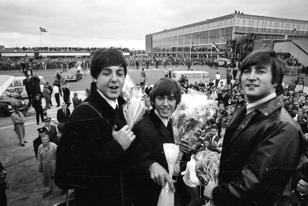 The Beatles ankommer til Kastruo for at give koncert i KB-hallen. Her ses de tre af dem, Poul McCartney, George Harrison og John Lennon.; The English rockband arrives in Kastrup Airport to play in KB-hallen. Here photographed Paul McCartney, George Harrison and John Lennon.