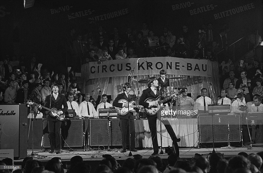 The Beatles performing at the Circus Krone-Bau in Munich on June 24, 1966. From left to right bass guitarist Paul McCartney, guitarist George Harrison, guitarist John Lennon, and drummer Ringo Starr in the back.