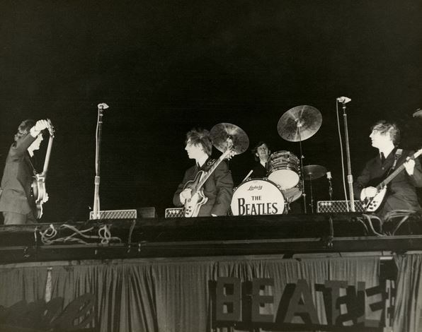 The Beatles prepare to play at the Gator Bowl on Sept. 11, 1964. High winds eventually ripped the cardboard letters spelling out “Beatles” away from the stage, recalled a concertgoer. (Vern Barchard/State Archives of Florida)