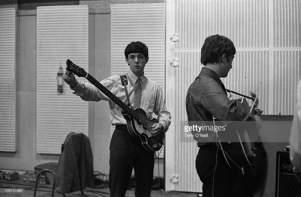 Paul McCartney and John Lennon of The Beatles in Studio 2 at Abbey Road in London during the recording session for the single 'She Loves You', 1st July 1963. McCartney tunes up his first Hofner 500/1 violin bass guitar.