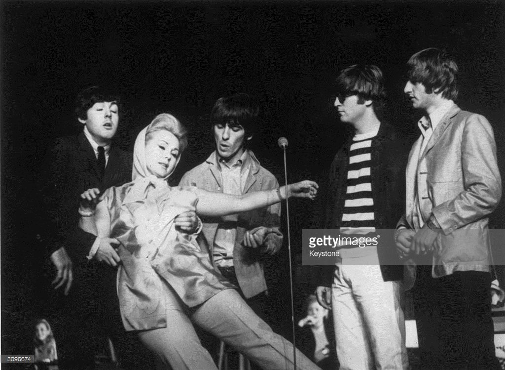 Hungarian born actress Zsa Zsa Gabor falling into the arms of Paul McCartney, during the 'Night Of A 100 Stars' charity show at the London Palladium, while his fellow Beatles (from left) George Harrison (1943 - 2001), John Lennon (1940 - 1980) and Ringo Starr look on.